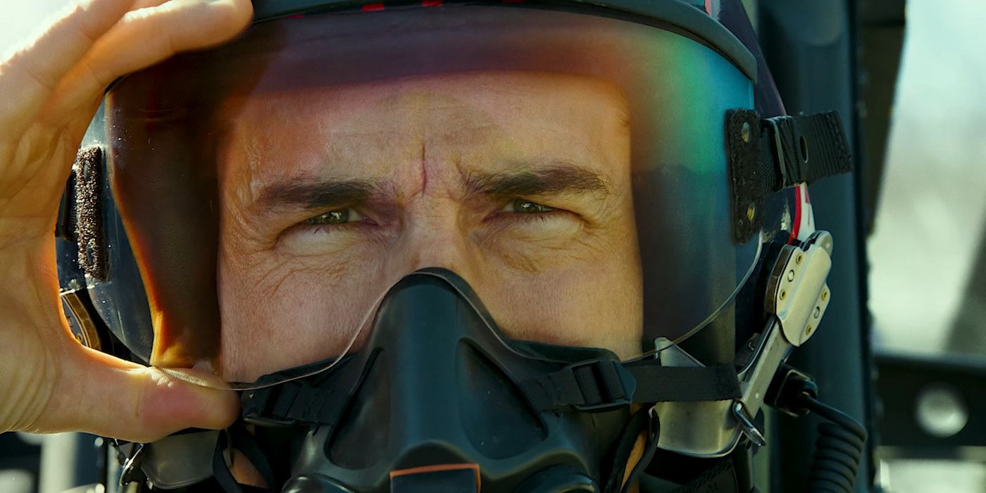 Top Gun 2'de Maverick karakterindeki Tom Cruise'un yüz siperi ve oksijen maskesi ile pilot kaskı takarken yakından görünümü