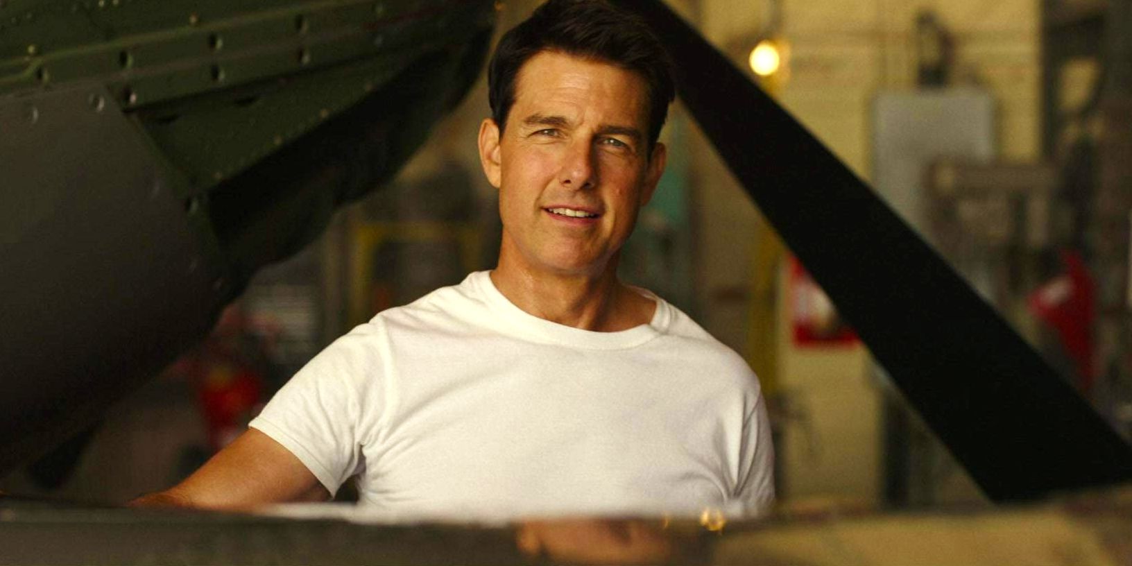 Top Gun: Maverick'te beyaz gömlek giyen ve uçağın yanında duran Maverick rolünde Tom Cruise