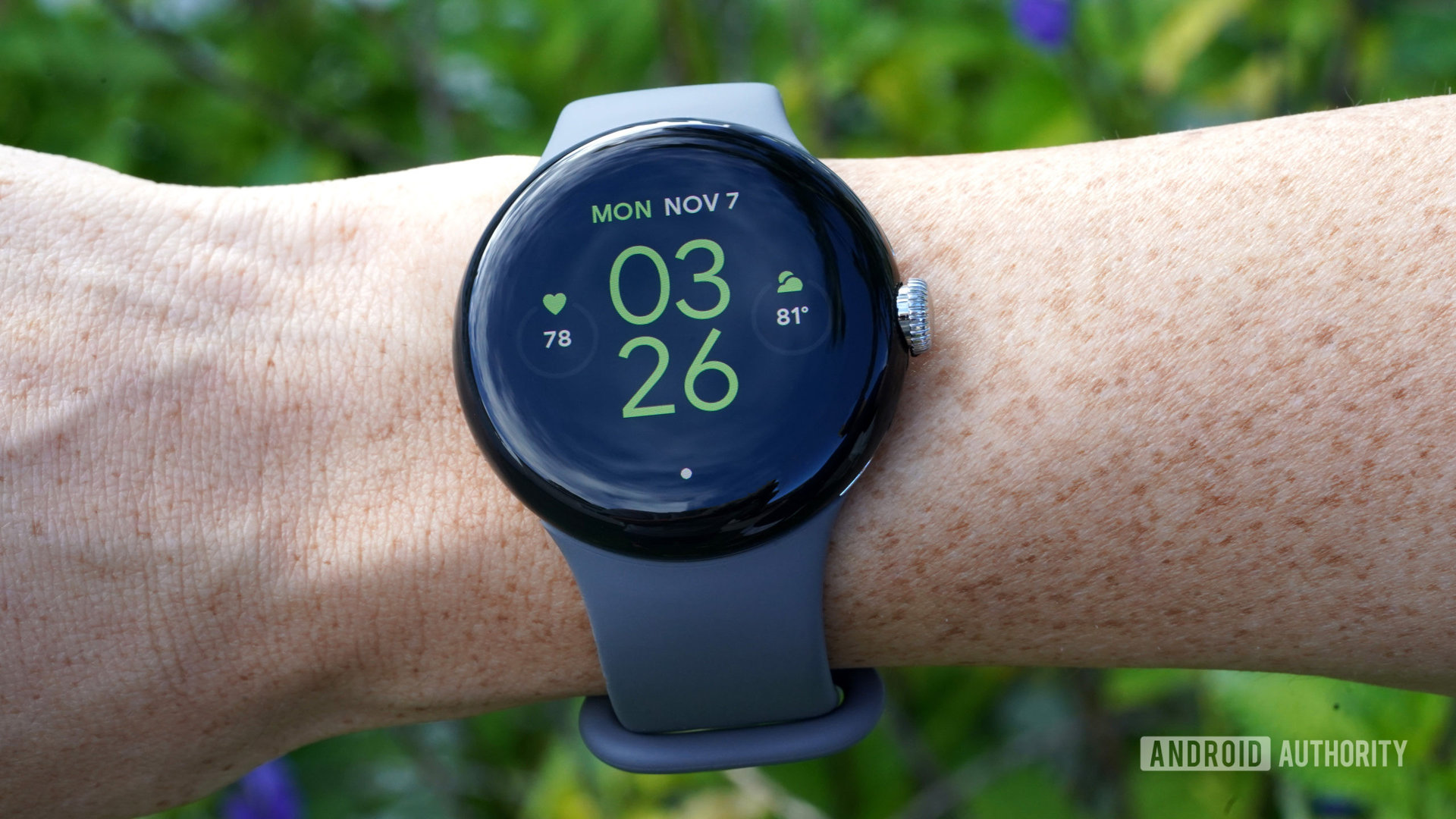 Kullanıcının bileğindeki bir Google Pixel Watch, saat yüzünü gösterir.