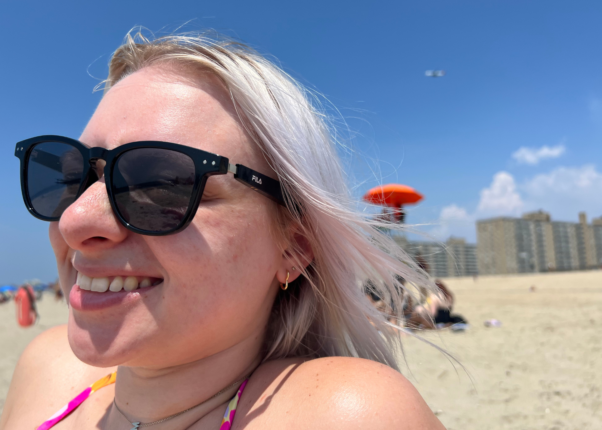 plajda siyah fila güneş gözlüğü takan kadın