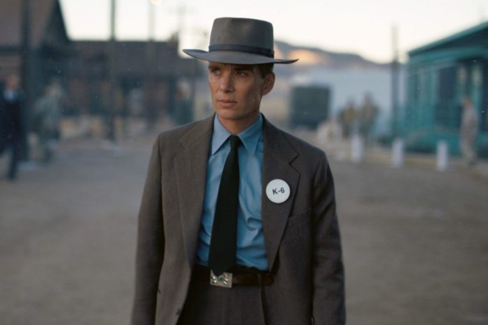 Cillian Murphy, Oppenheimer'da J Robert Oppenheimer rolünde.  Gri bir takım elbise ve şapka giyiyor.